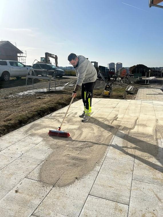 Einkehren von Fugensand auf einer neu verlegten Terrasse